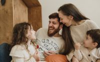 Happy family enjoying quality time with their children indoors, sharing laughter and joy.